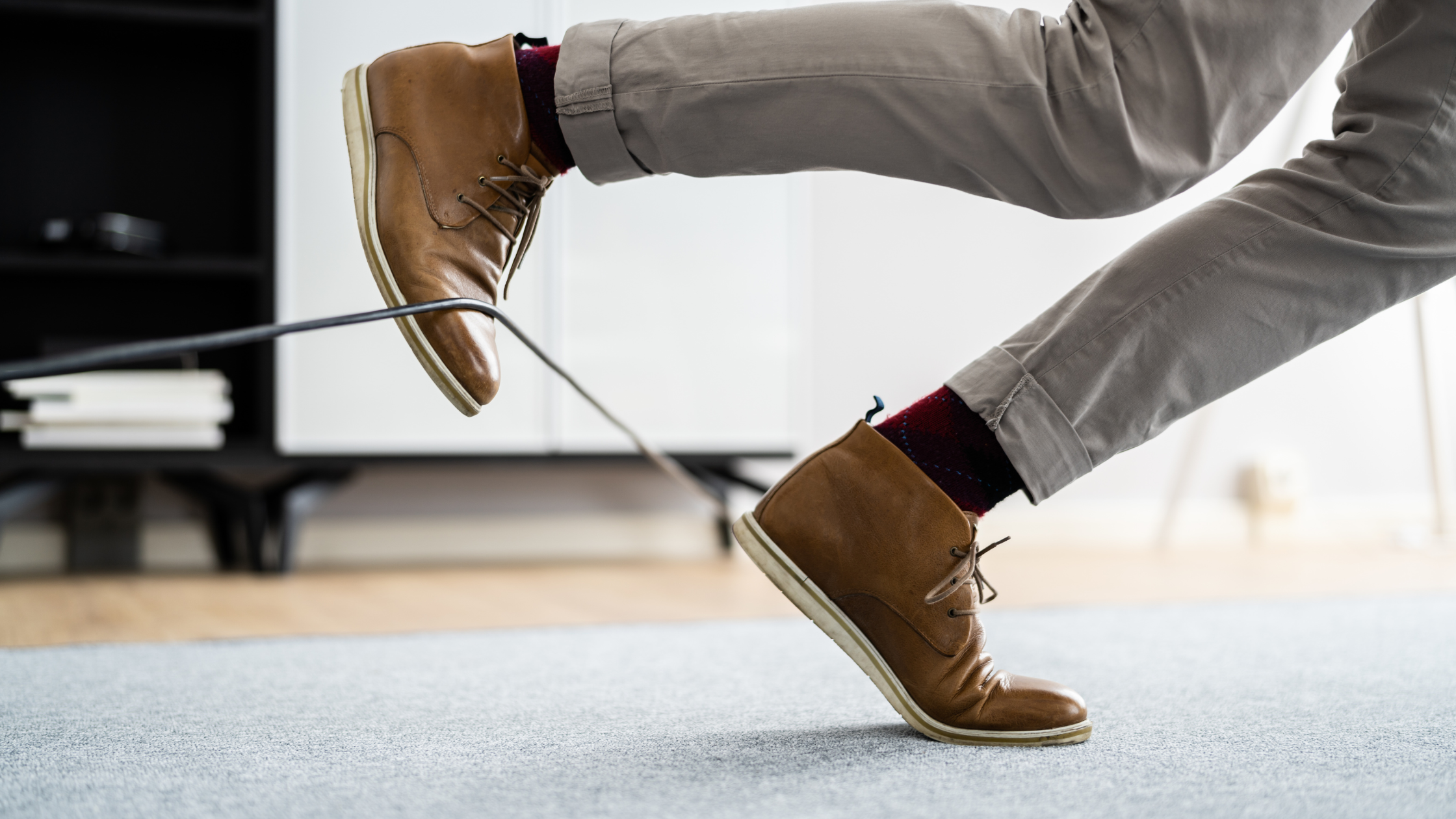 Slips, trips and falls: Image of male tripping over wires in an office setting